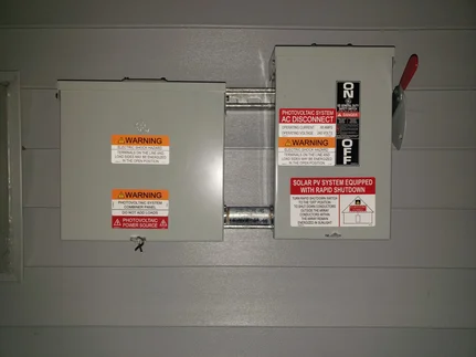 The completed AC Combiner and Rapid Disconnect with NEC labels.